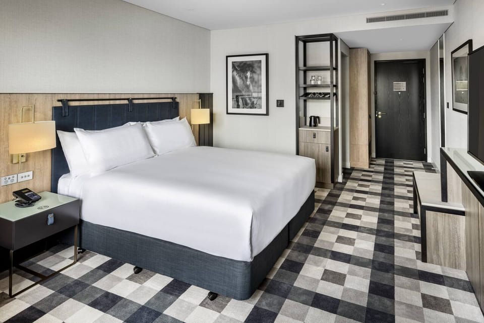DoubleTree by Hilton Auckland Karaka – King Guestroom showing the console work surface and wall-mounted TV