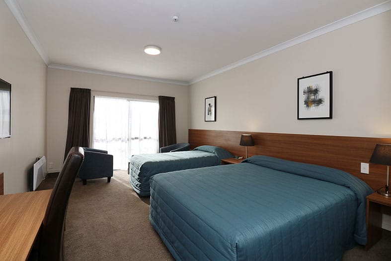 The Victoria Hotel Dunedin – Standard Room with queen and single bed, armchairs and writing desk