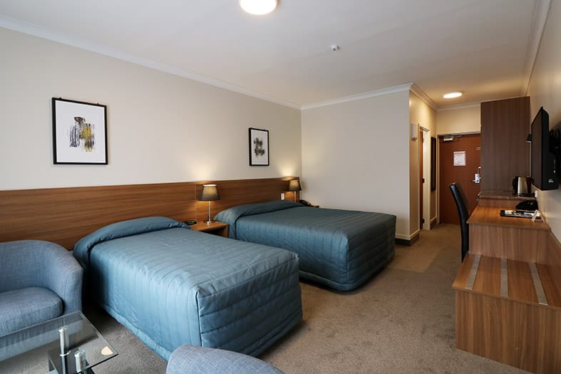 The Victoria Hotel Dunedin – Standard Room twin layout with wall-mounted TV and tea and coffee tray